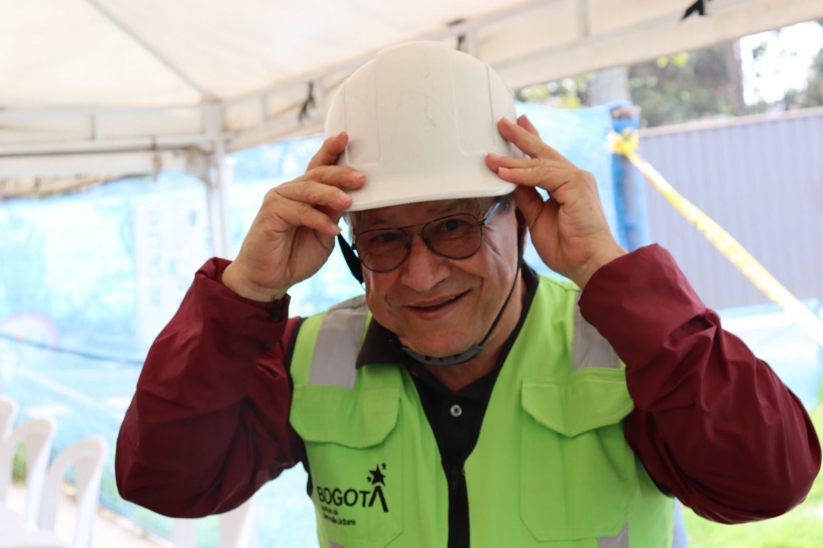 Un hombre sonrie a la cámara mientras se ajusta el caso