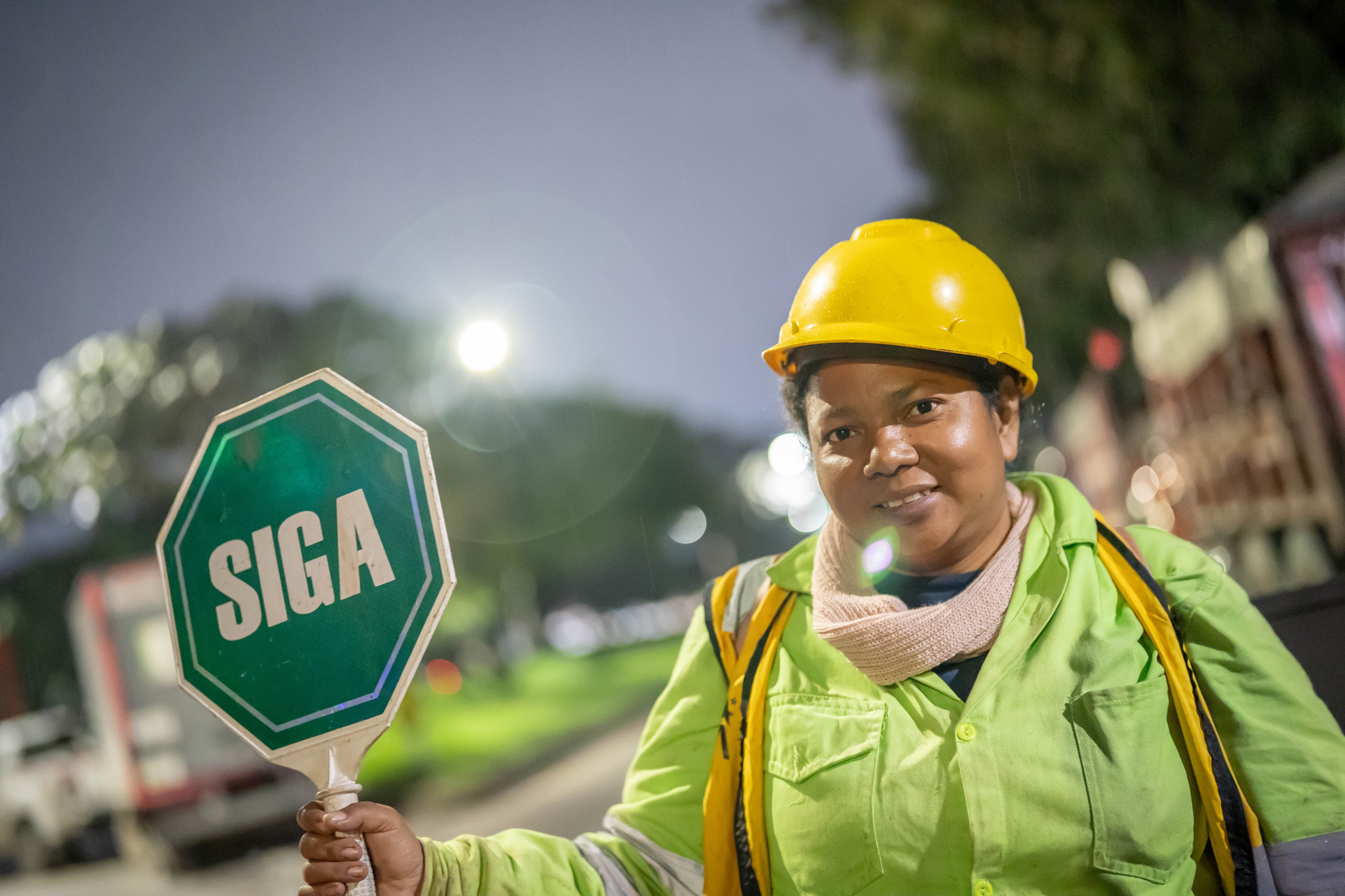 En medio de la noche, las mujeres encargadas de dar indicaciones al tránsito, mantienen una sonrisa
