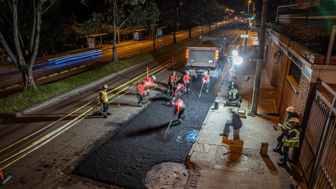 Grupo de trabajadores de obra en jornada nocturna trabajan en el arreglo de la malla vial