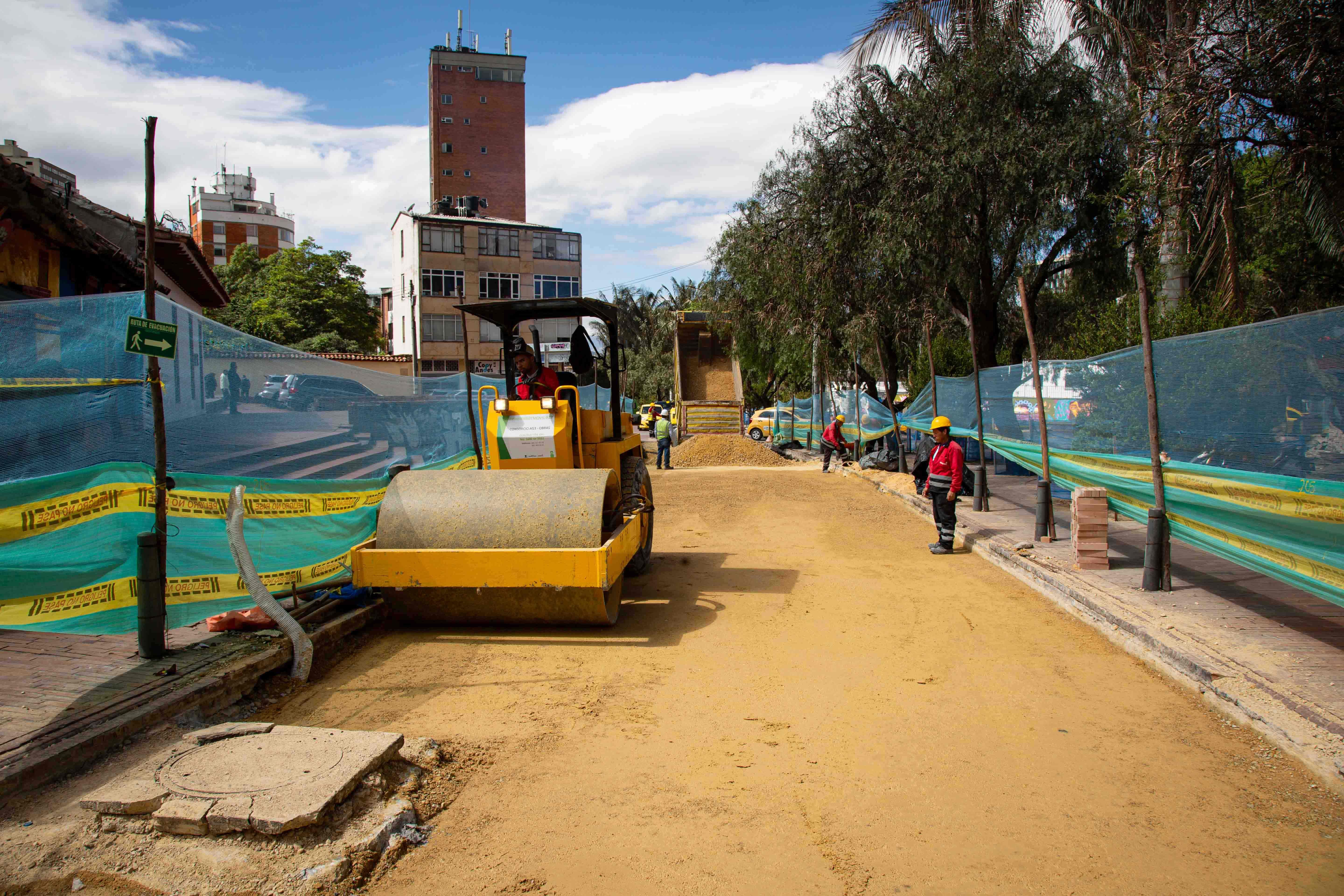 Un operario maneja una maquina aplanadora y otro, a su lado, le da indicaciones