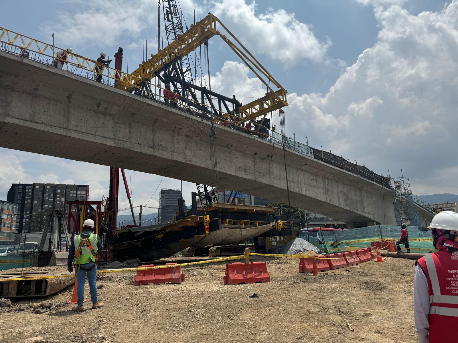 Empleados de obra miran el proceso de nivelación de la formaleta que se desbalanceó en el proceso de construcción del puente