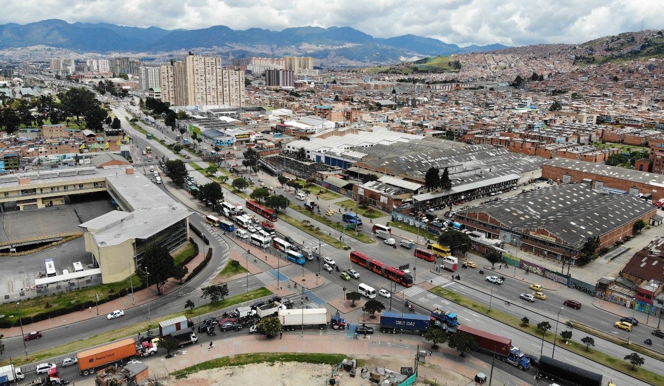 Un grupo de trabajadores  de obra está de espalda a la cámara mientras vierte cemento en las bases de acero.
