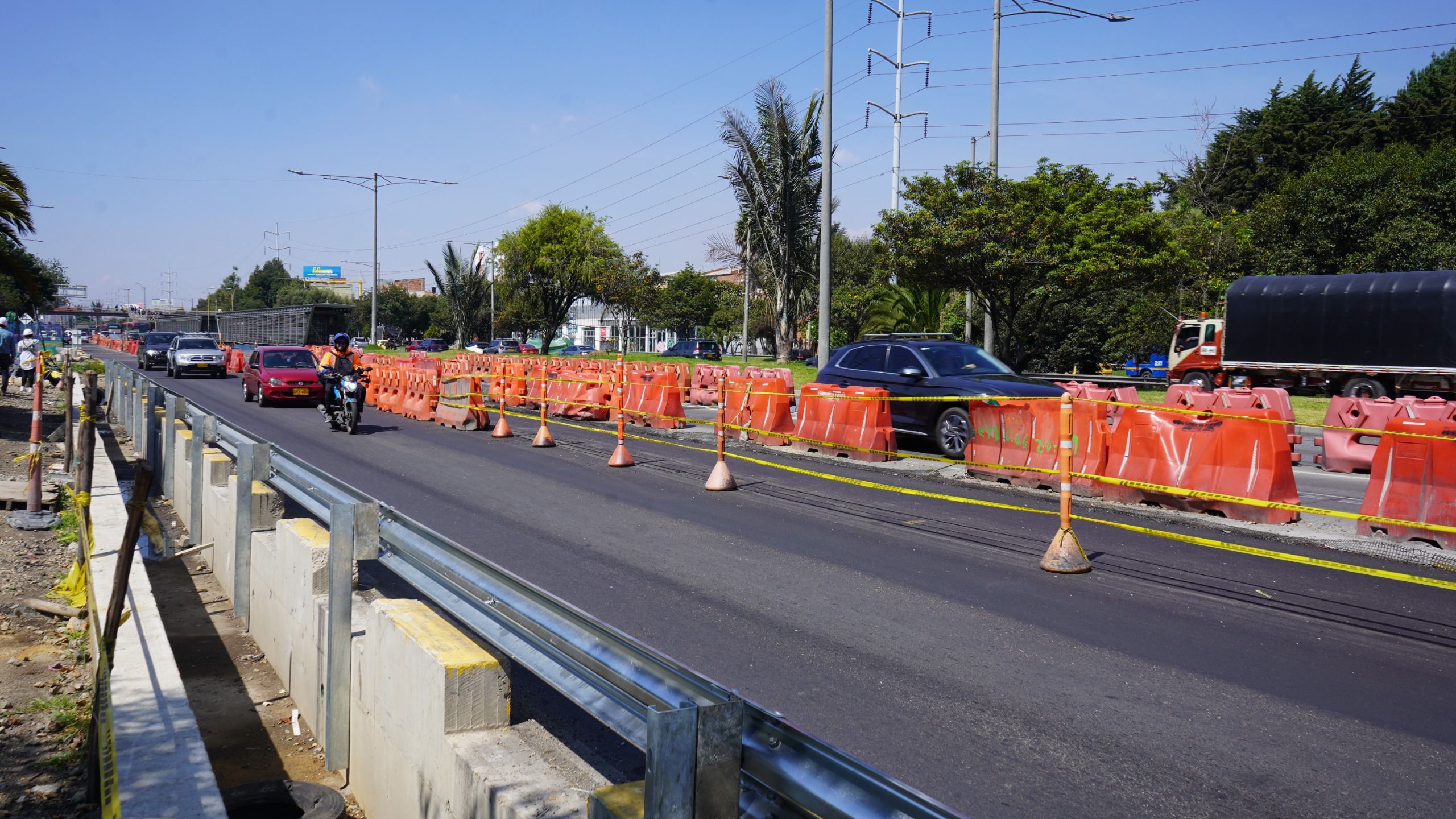 Fotografía de la autopiesta norte en la que se ven unos maletines de construcción separando la vía y una moto y varoos transitando por el carril libre