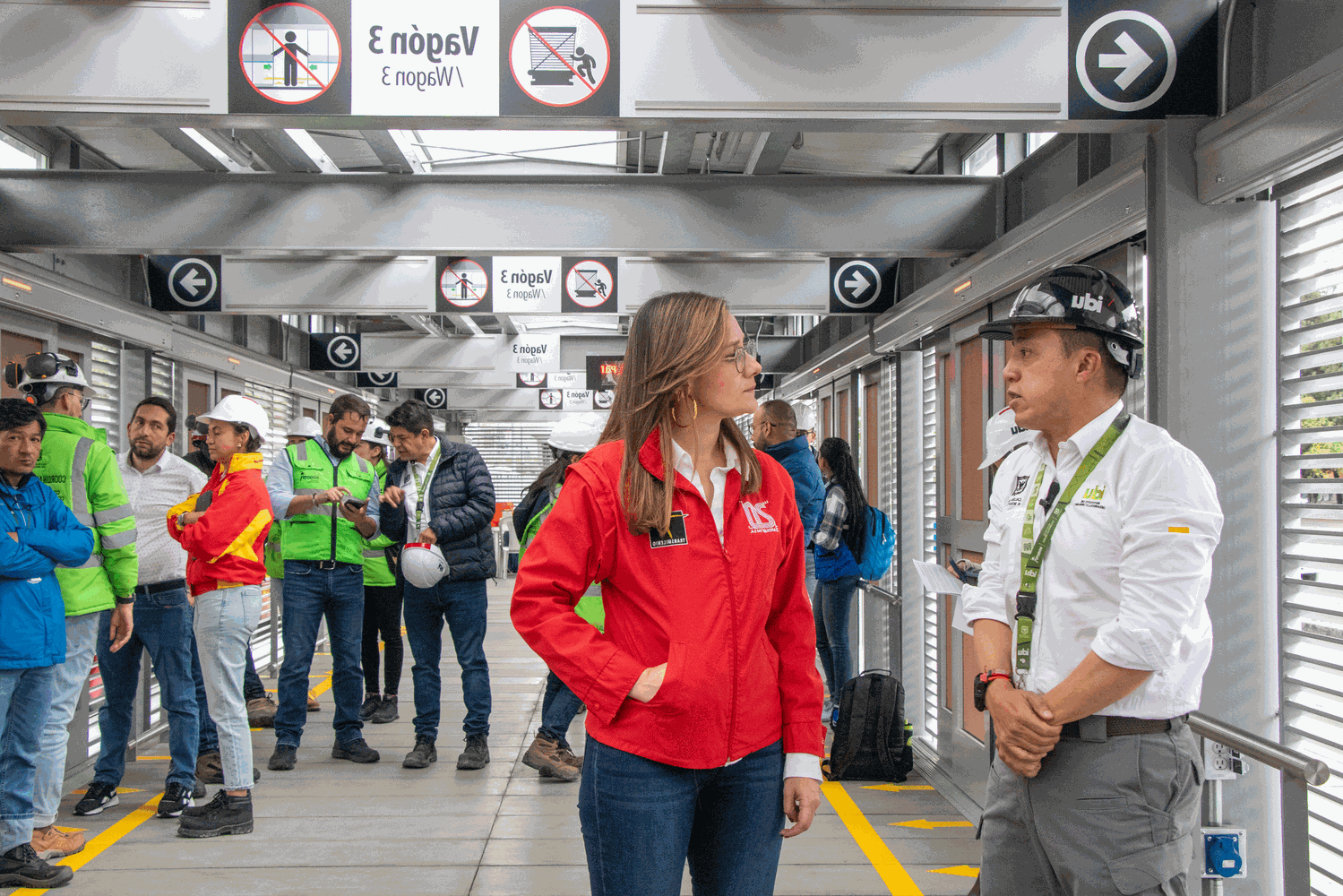 Adelante el director del IDU y la gerente de TransMilenio conversan. Destrás de ellos un grupo de personas de las dos entidades también intercambian conceptos