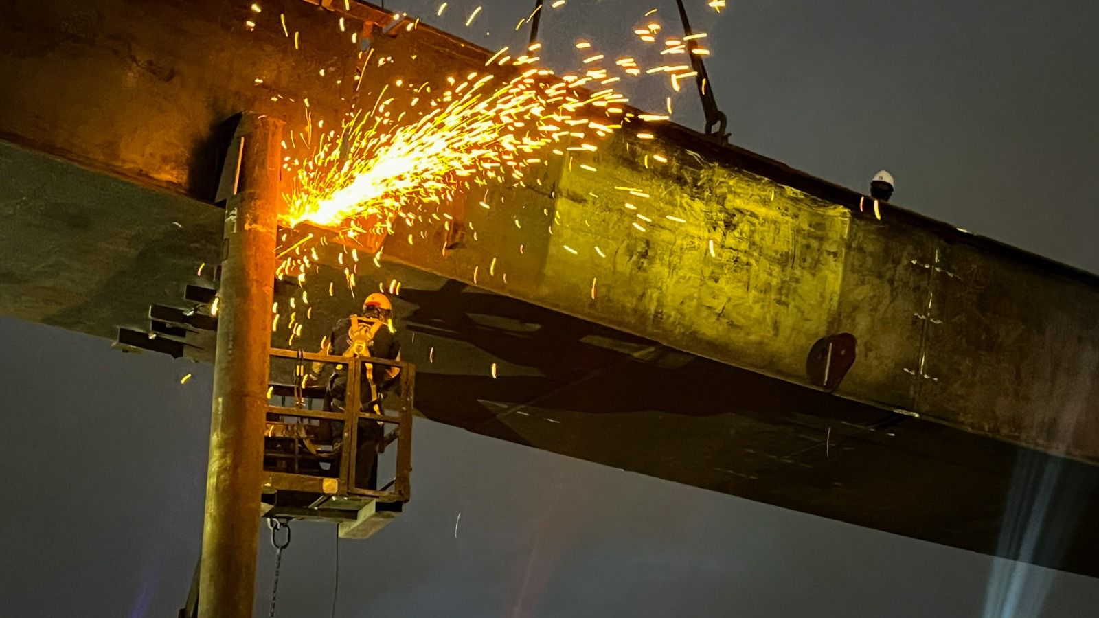 Personal de la obra soldan la viga izada durante la jornada nocturna