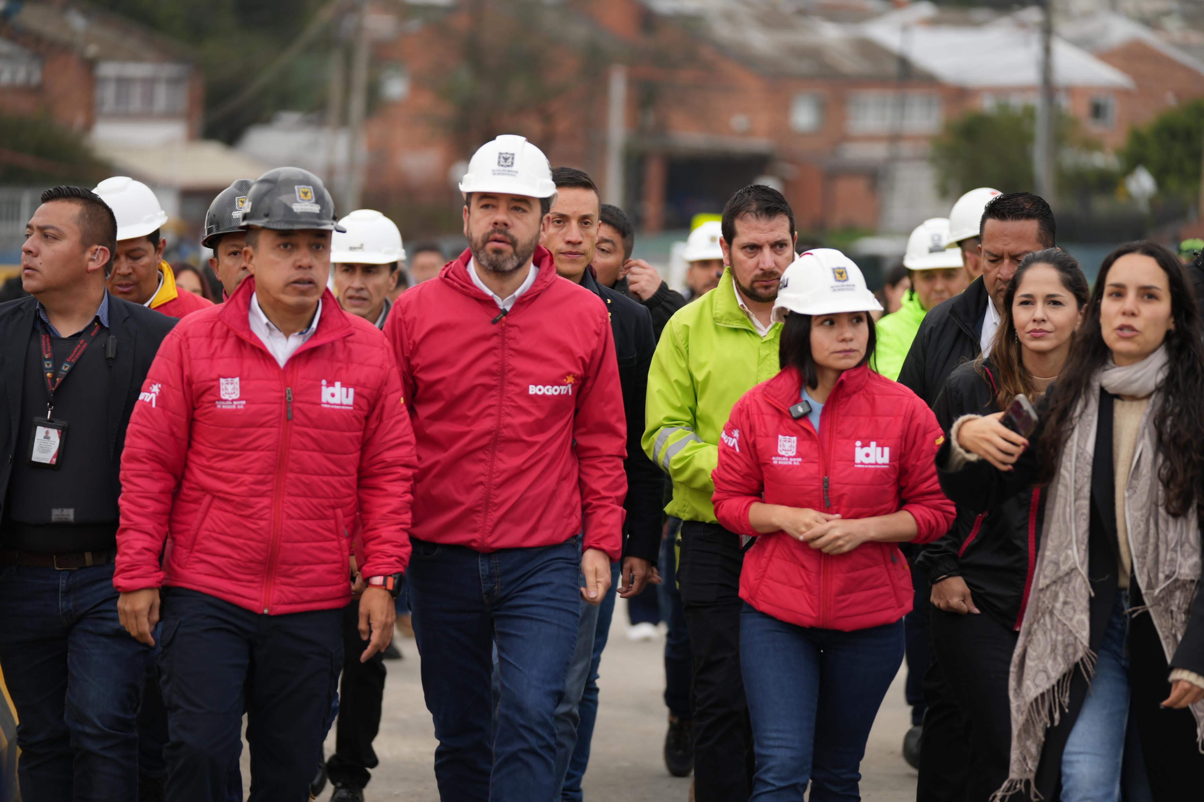 El alcalde, Carlos Fernando Galán, la secretaria de Movilidad, Claudia Díaz, y el director del IDU, Orlando Molano, junto a los trabajadores de obra antes de la habilitación de los puentes de la calle 127 con av. Boyacá