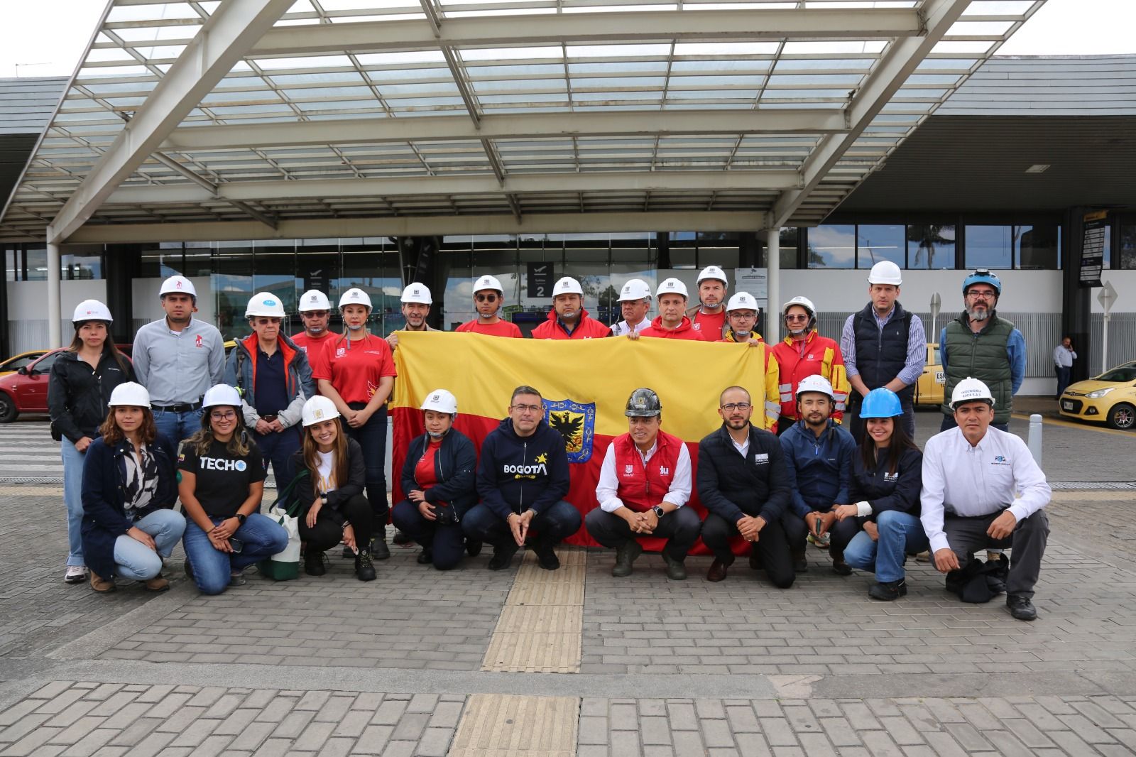 Grupo de ingenieros y especialistas de Bogotá posan con la bandera de la ciudad antes de viajar a evaluar estructuras por el sismo.
